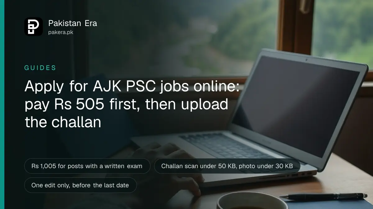 A young job applicant's hands on a laptop keyboard at a wooden table in a home in Muzaffarabad, with green hills through the window