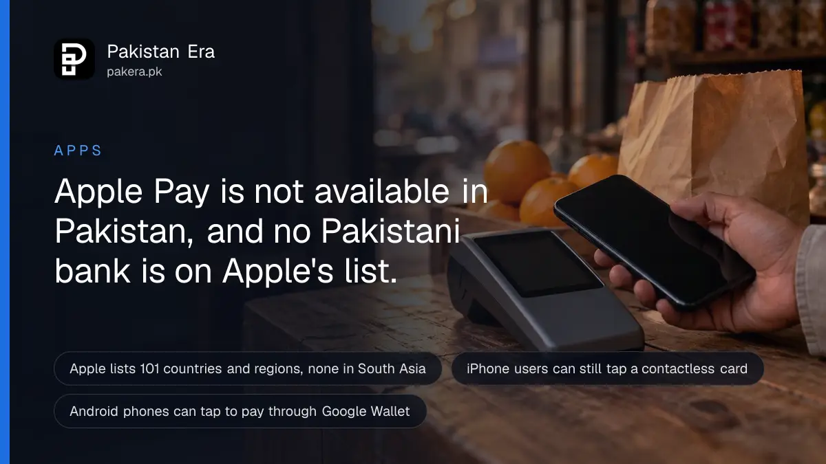 A hand holding a phone near a card machine with a blank screen on a small shop counter in Karachi