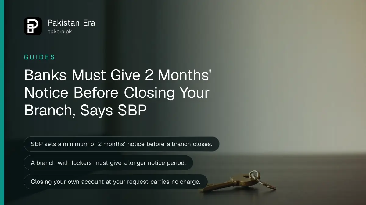 A brass key resting on a dark wooden table against a plain cream wall for an article on a closing bank branch
