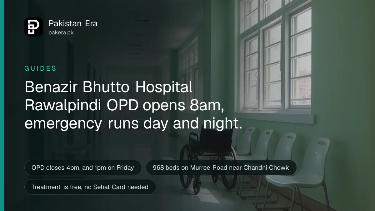 A clean, empty hospital corridor with soft daylight and a folded wheelchair against the wall