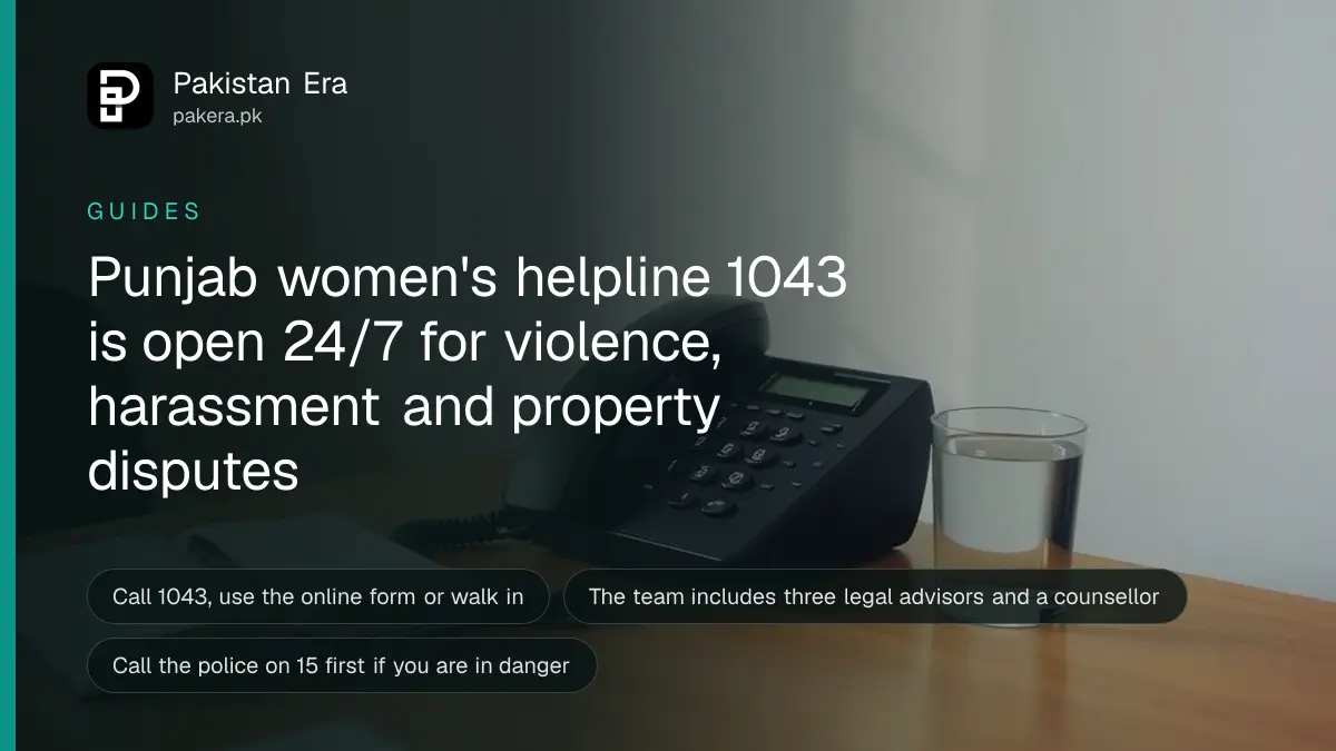 A plain telephone on a wooden desk beside a notebook and a glass of water in a quiet office room