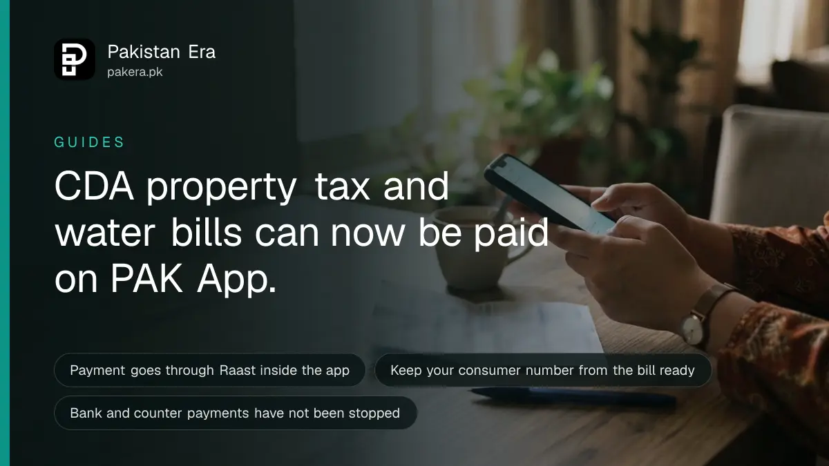 Hands holding a smartphone above a paper utility bill on a wooden table in an Islamabad home