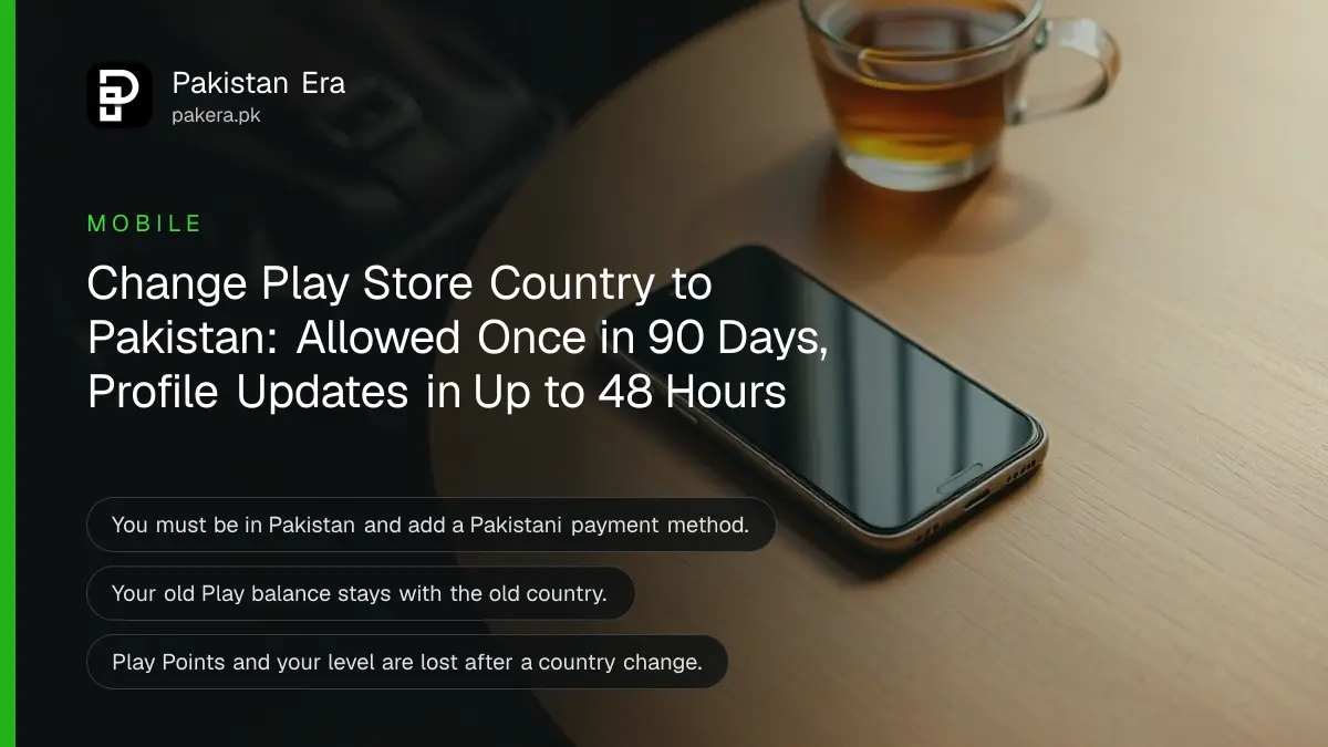 A smartphone lying face up with a dark screen on a wooden table beside a small travel bag and a cup of tea