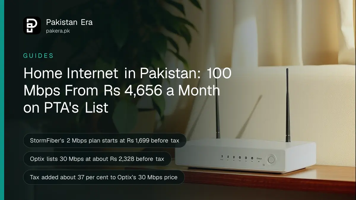 A plain white box with two small antennas on a wooden shelf beside a green potted plant, a sofa and sheer curtains behind, soft afternoon light in a Lahore home