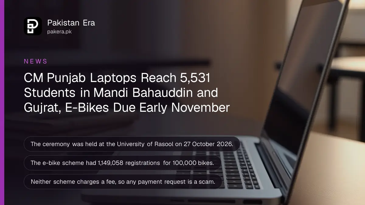 A silver laptop on a library desk beside a stack of notebooks