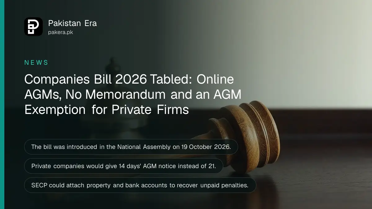 A plain wooden gavel beside a brass desk bell on a dark wooden table against a plain cream wall in soft daylight