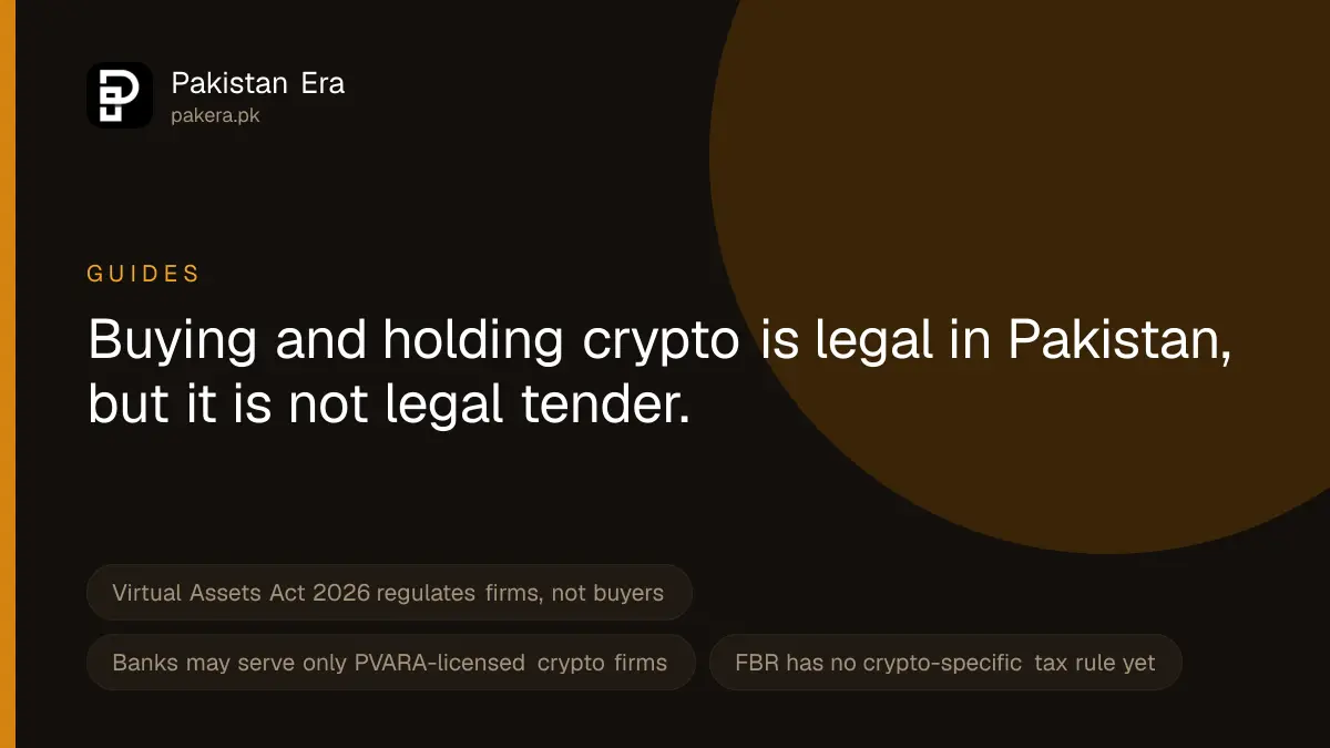 A hand holding a smartphone with a dark screen over a desk with a hardware wallet and a cup of tea