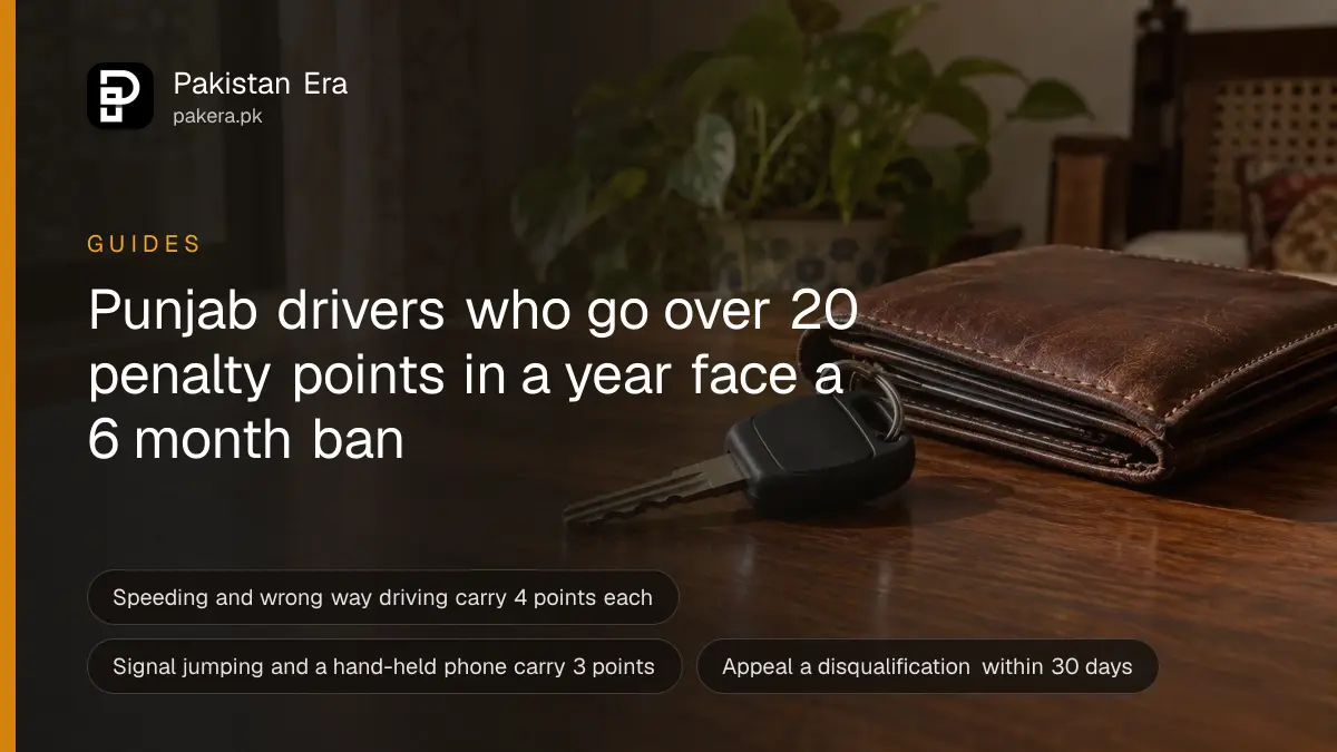 A single car key with a plain black fob resting on a wooden table beside a folded brown leather wallet in soft window light