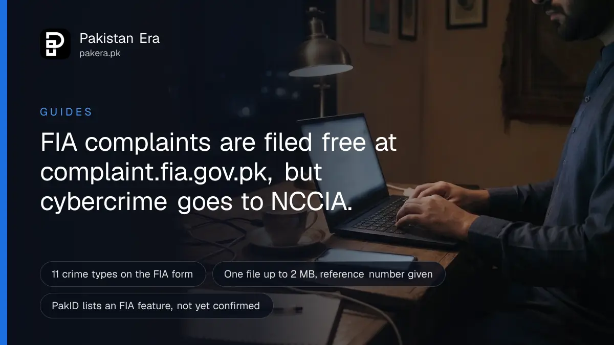 Hands typing on a laptop at night with a phone lying on the desk, as someone files an FIA complaint online, screens unreadable