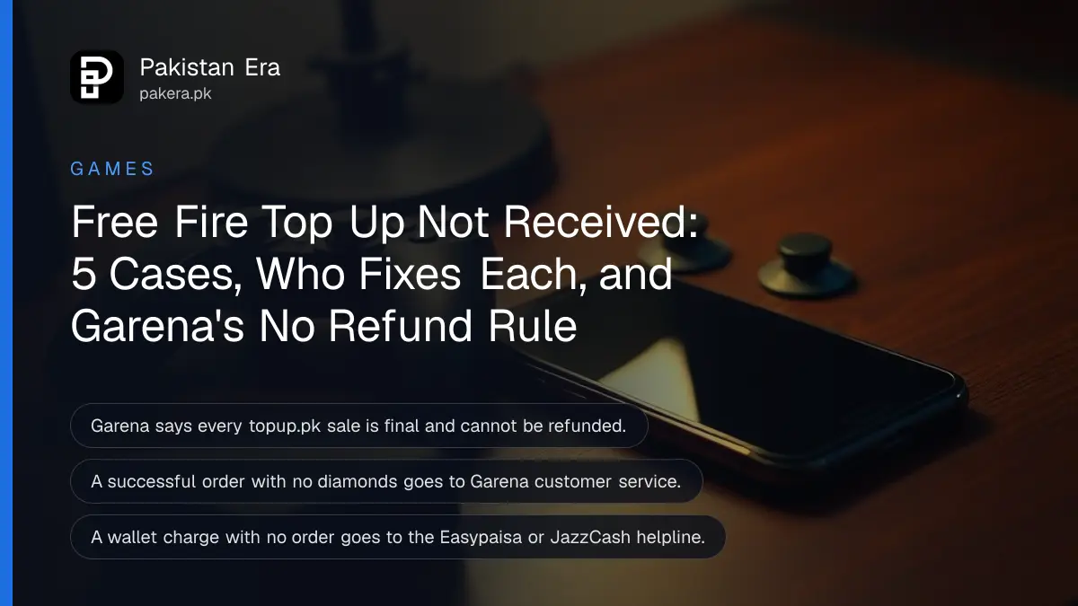 A smartphone lying face up with its screen dark beside a black game controller on a desk at night under a warm lamp