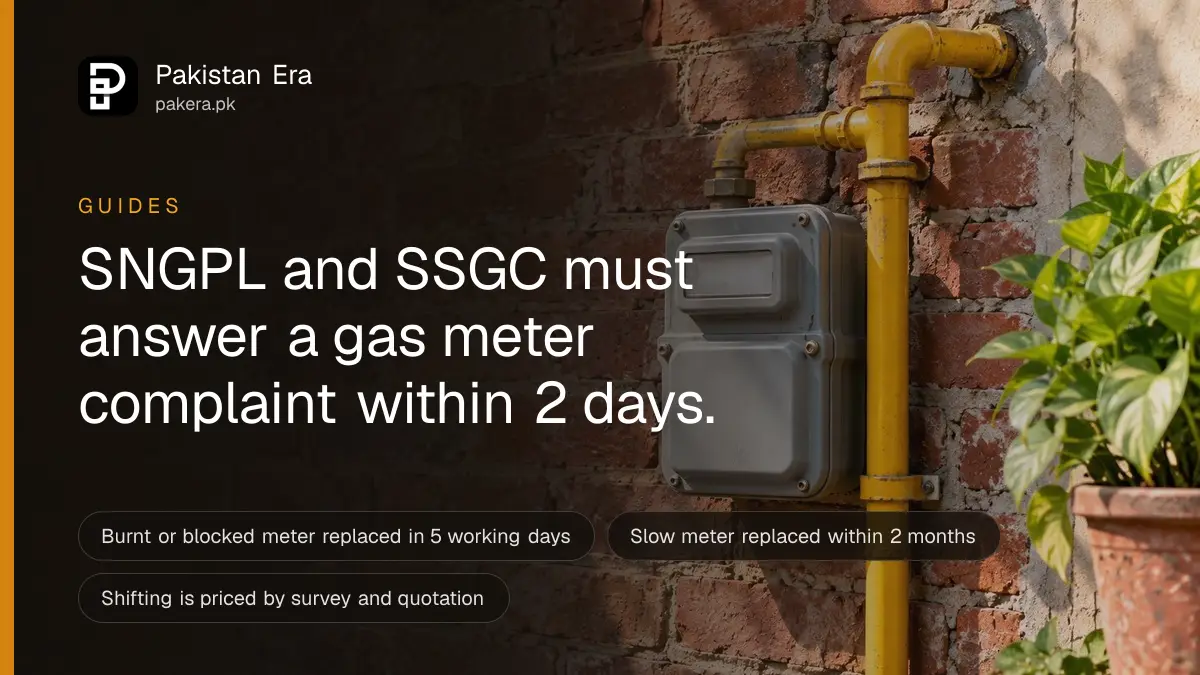 A grey gas meter box mounted on a red brick wall with a yellow pipe beside it