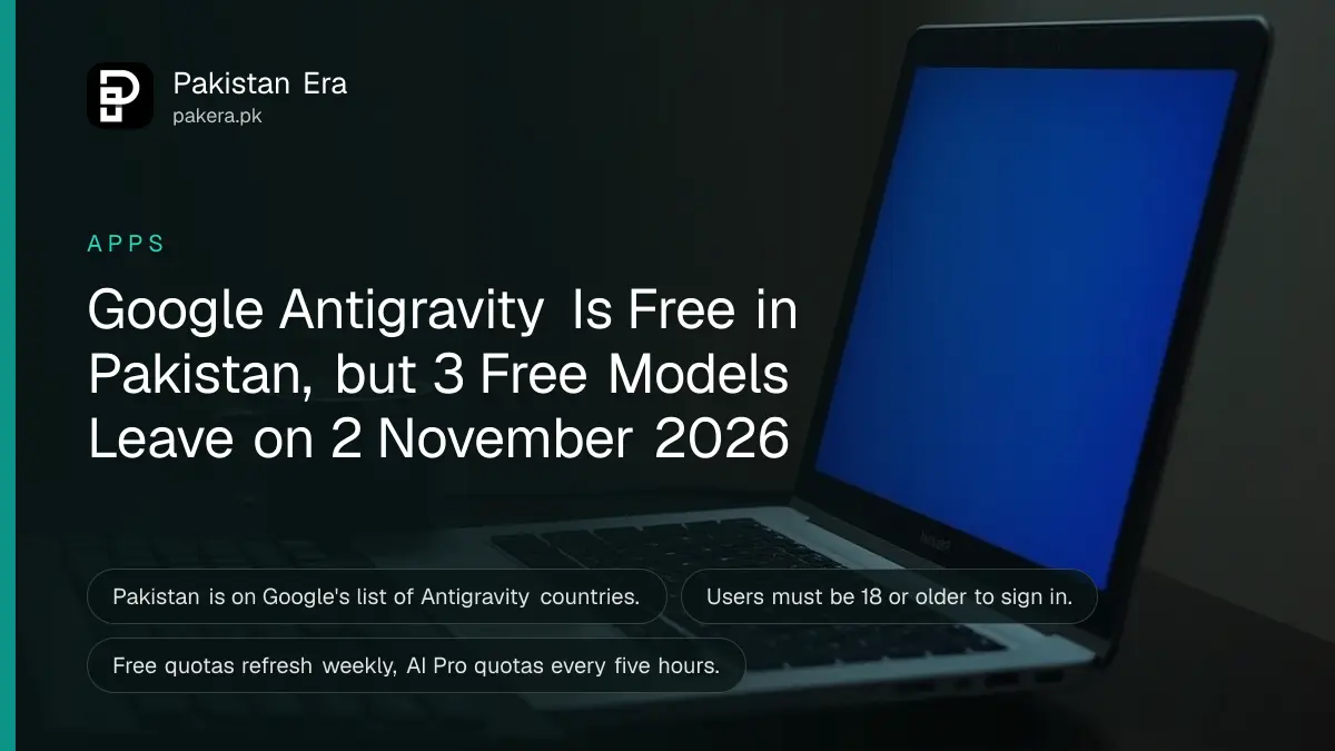An open silver laptop seen from the side on a desk with a mechanical keyboard and a mug of tea, screen glowing blue in a dark room
