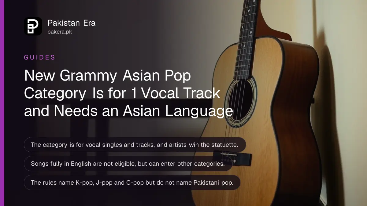 A wooden acoustic guitar against a dark wooden table, for an article on the new Grammy Asian pop category