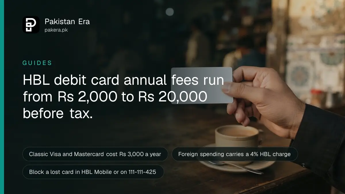 A hand holding a plain blank bank card between two fingers over a café table in Karachi
