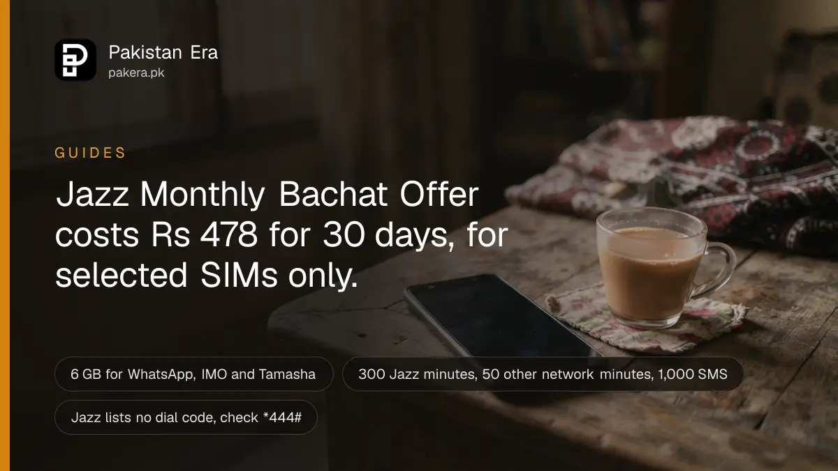 A mobile phone with a dark screen lying on a wooden table beside a cup of chai in Lahore