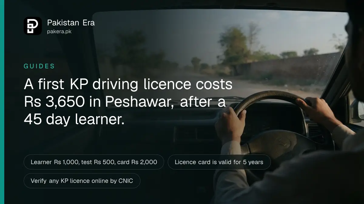 A learner driver's hands on a steering wheel, looking through the windscreen at an empty road near Peshawar