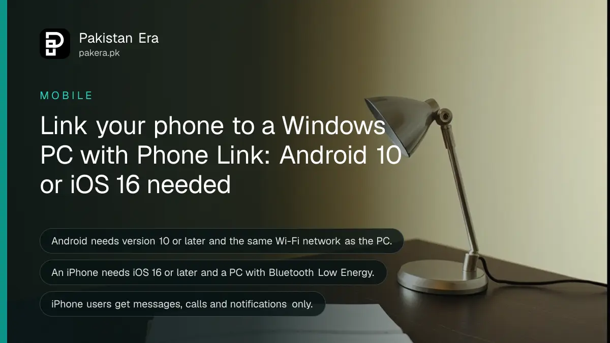 A small desk lamp and a closed notebook on a dark wooden table, for a guide to linking a phone to a Windows PC