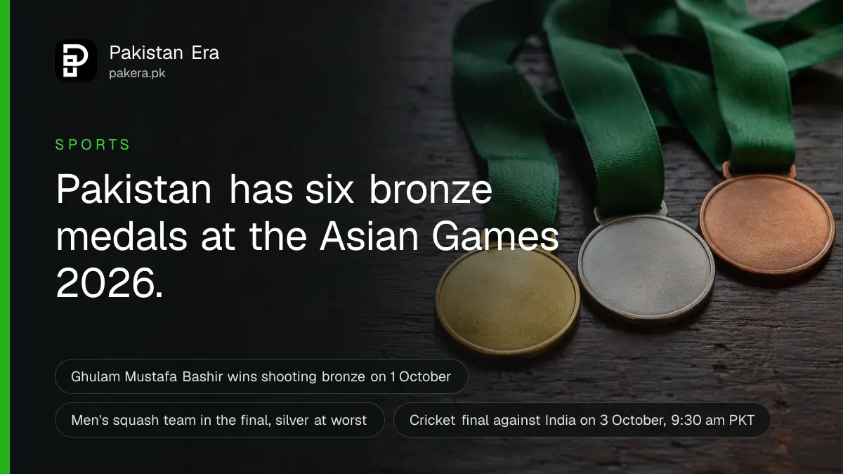 Three plain bronze-coloured medals with green ribbons resting on a dark wooden table in soft window light