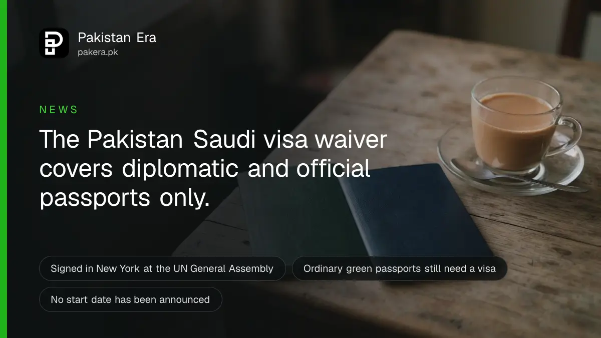 Two closed passports with plain covers on a wooden table beside a cup of tea