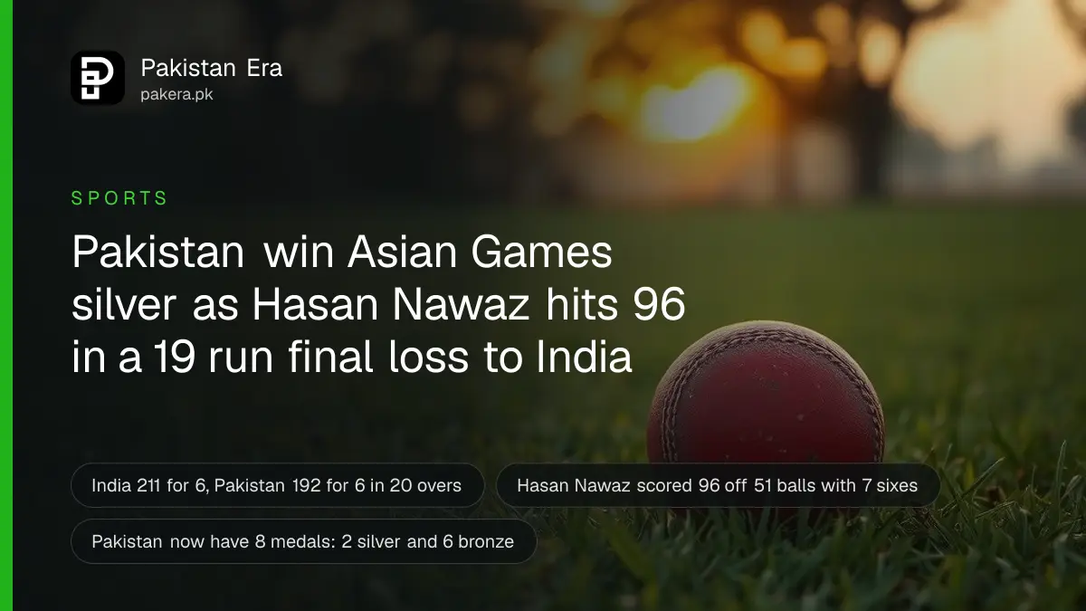 A red cricket ball resting on green grass at sunset on a wide empty field