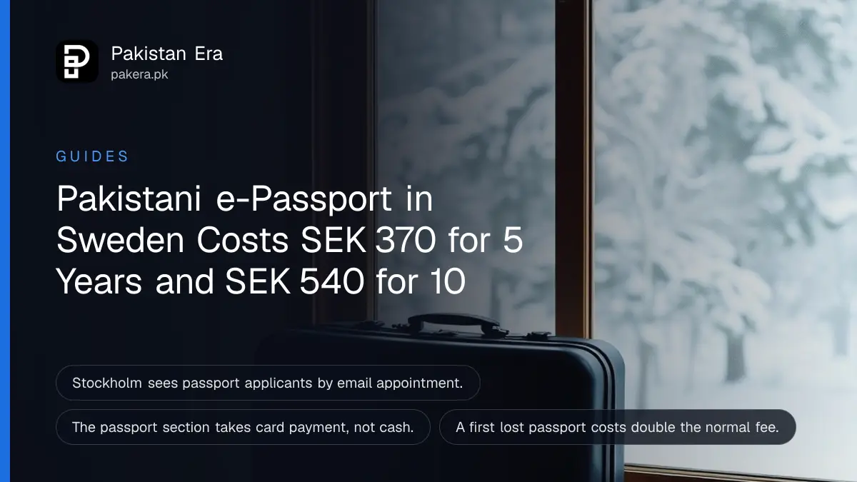 A small travel suitcase beside a window with snowy pine trees outside in soft winter light