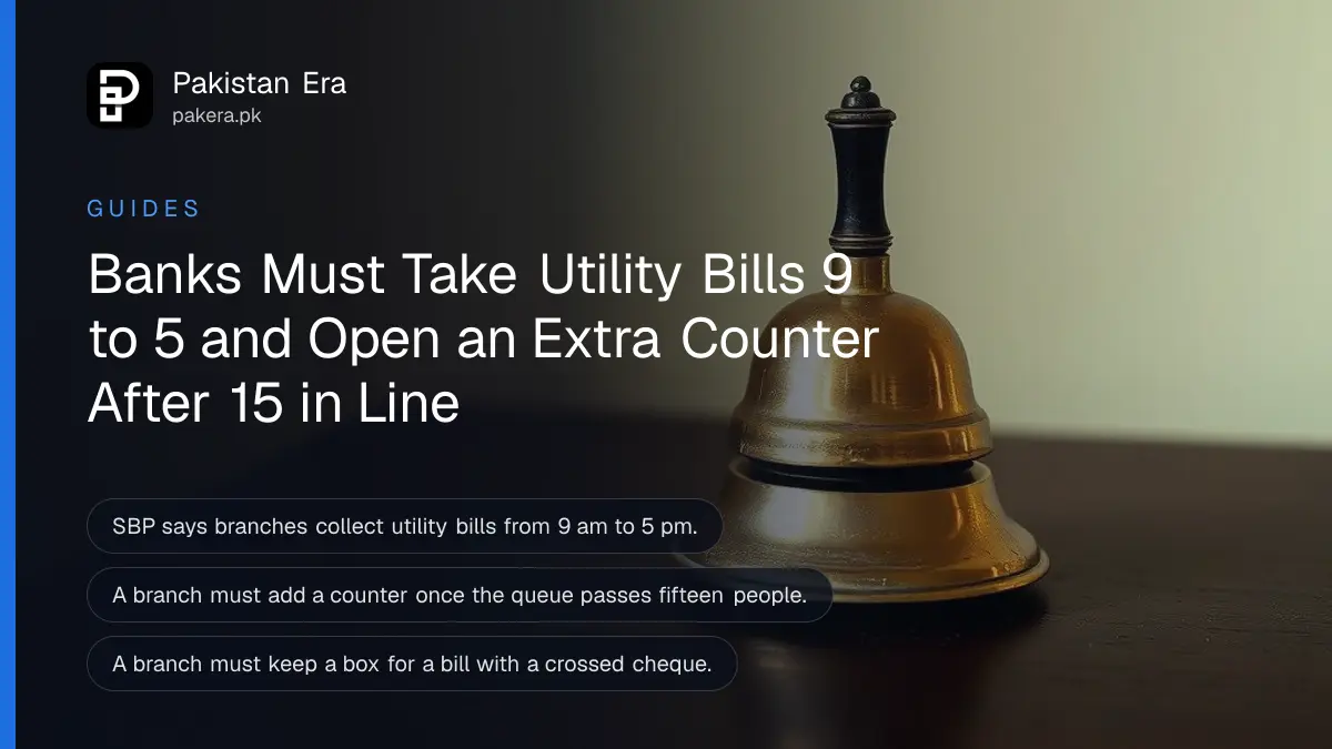 A brass bell on a dark wooden table against a plain cream wall for an article on paying bills at a bank counter