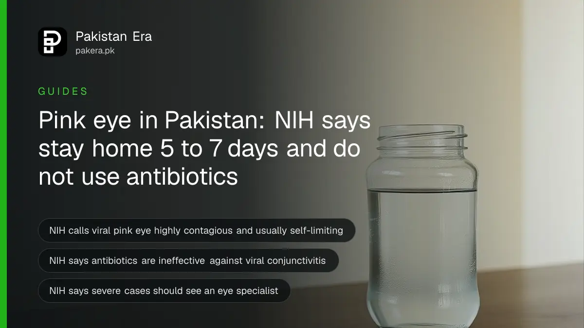 A clear glass jar of water on a dark wooden table against a cream wall, for an article on pink eye advice from NIH
