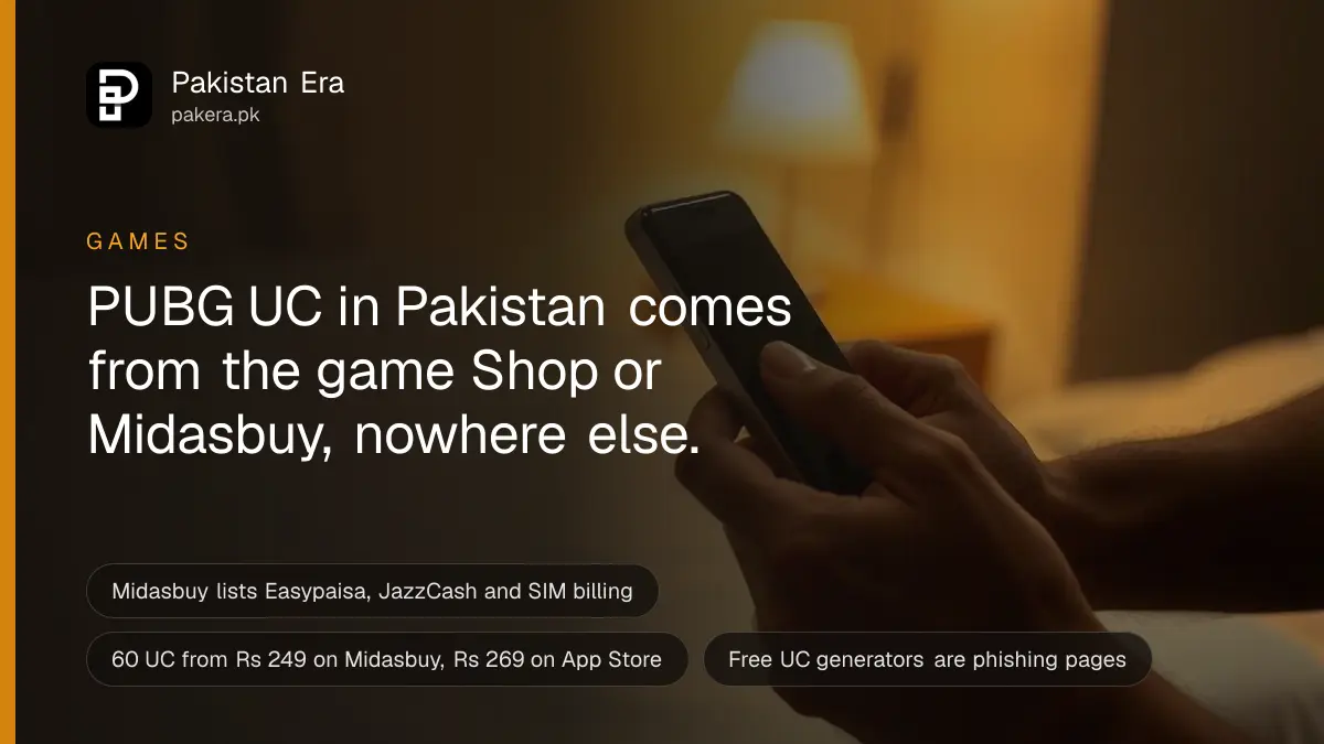 Two hands holding a phone sideways with a dark screen in a dim room lit by a warm lamp in Lahore
