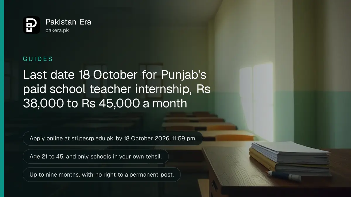 An empty government school classroom in Punjab with wooden desks, a teacher's table and morning light from the windows