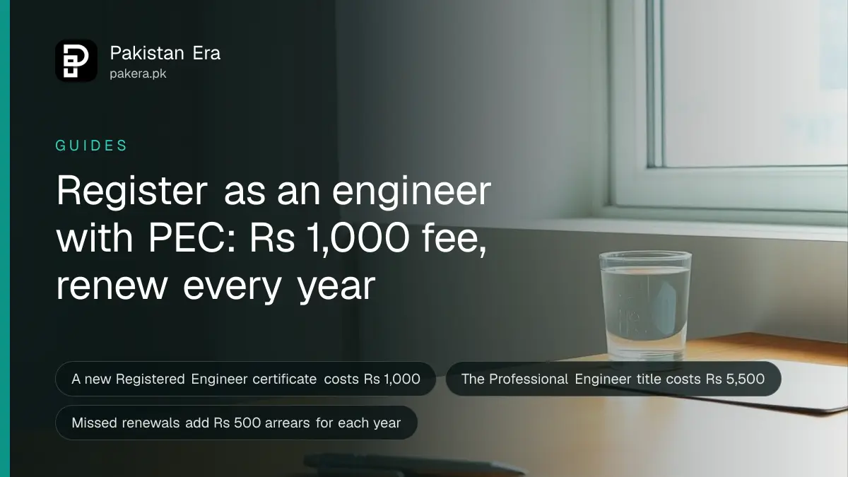 A plain wooden desk with a pen, a ruler and a glass of water in a quiet engineering office in Pakistan