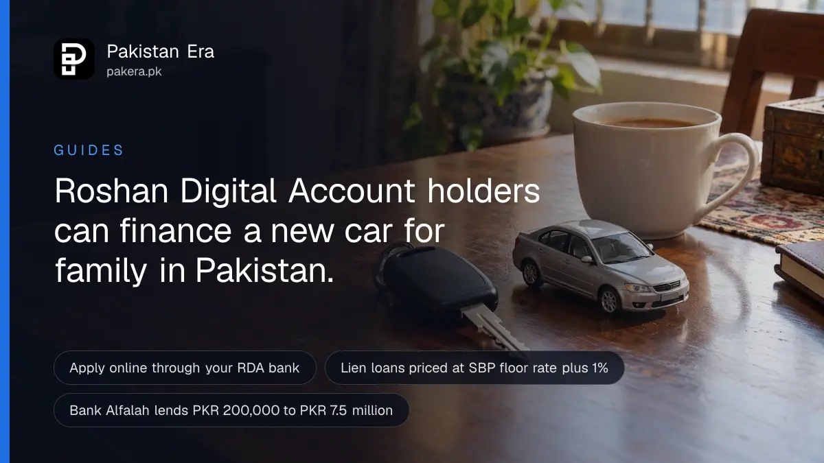 A car key and a small silver toy car resting on a wooden desk beside a cup of tea