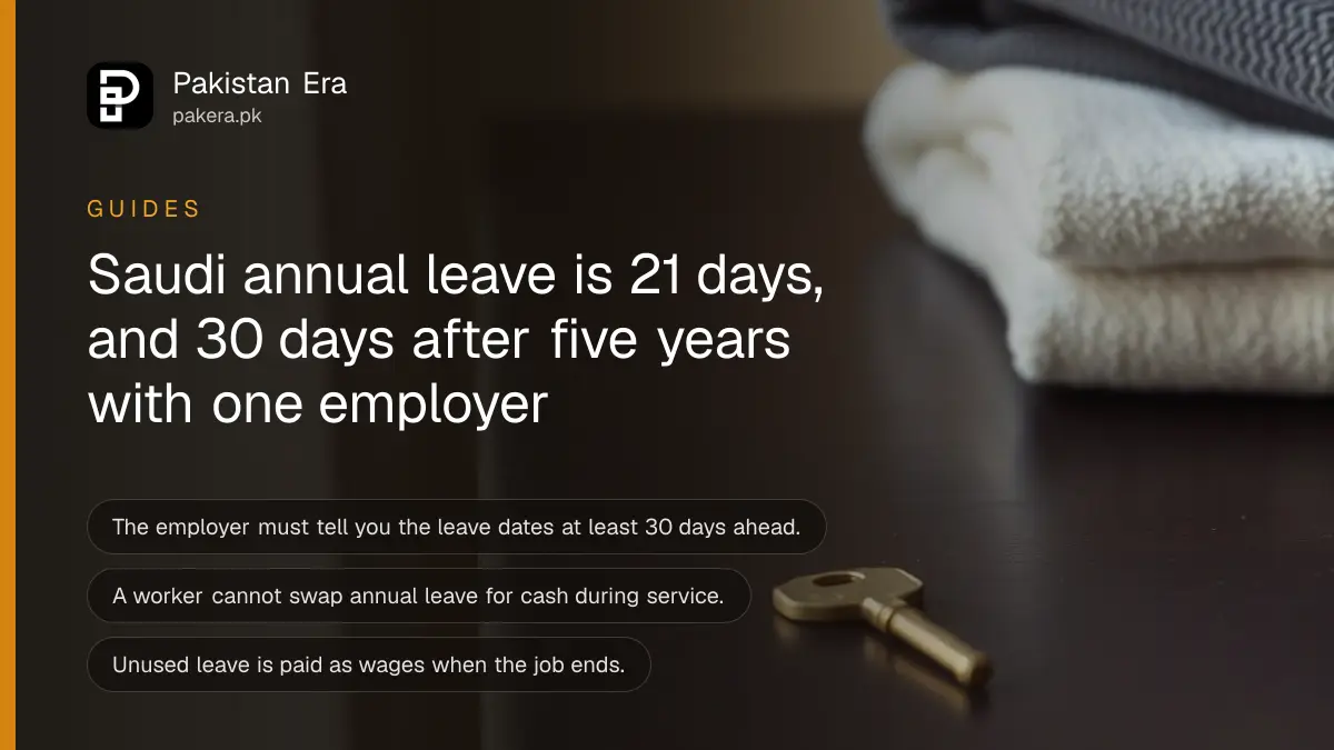 A brass key and a folded towel on a dark wooden table, for a guide on annual leave days under Saudi Labor Law