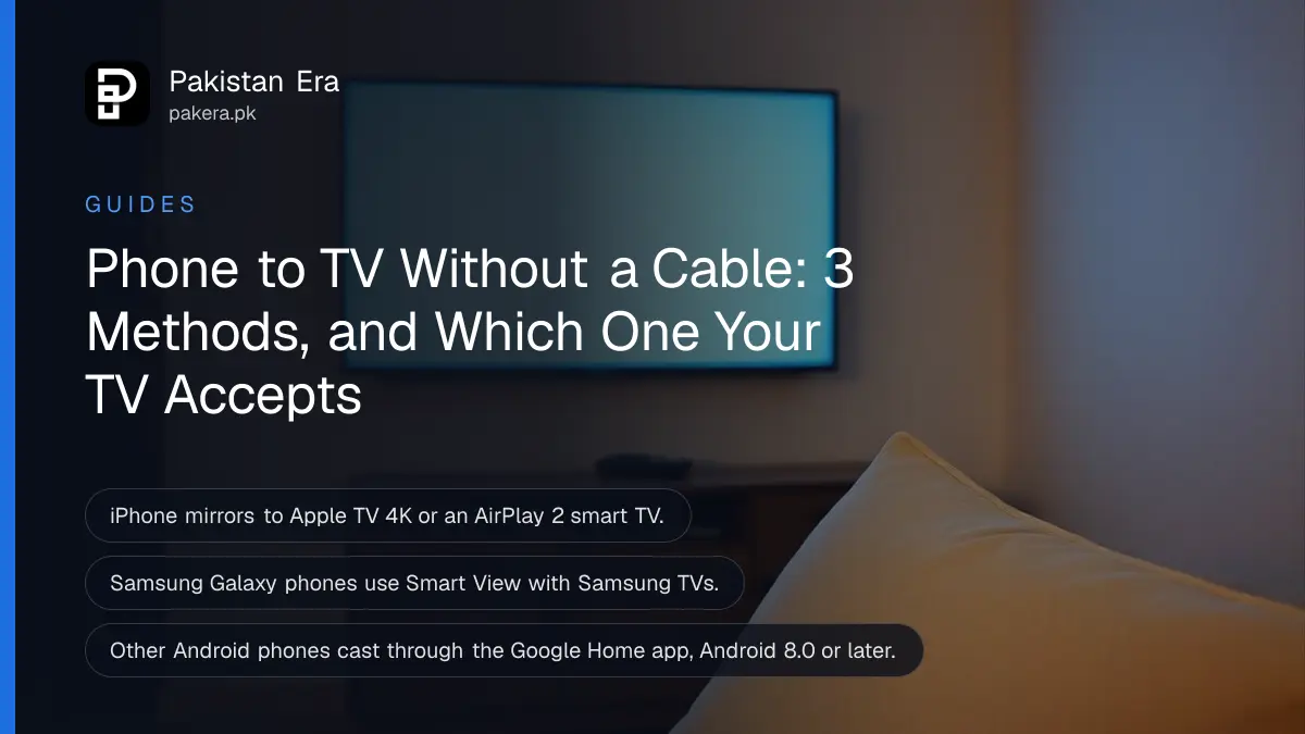A living room with a large wall-mounted television glowing softly blue above a wooden cabinet, a smartphone lying on a sofa cushion