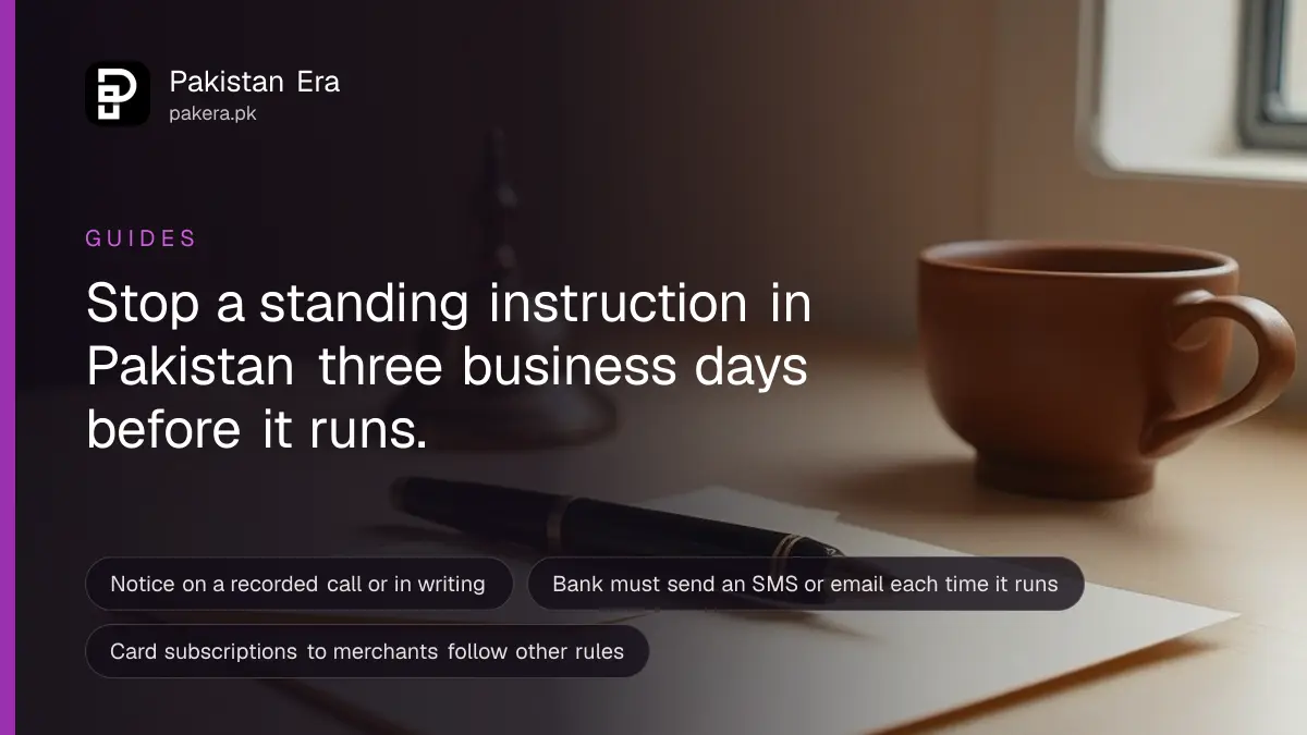 A fountain pen on a blank envelope beside a brass desk bell and a cup of tea on a wooden desk