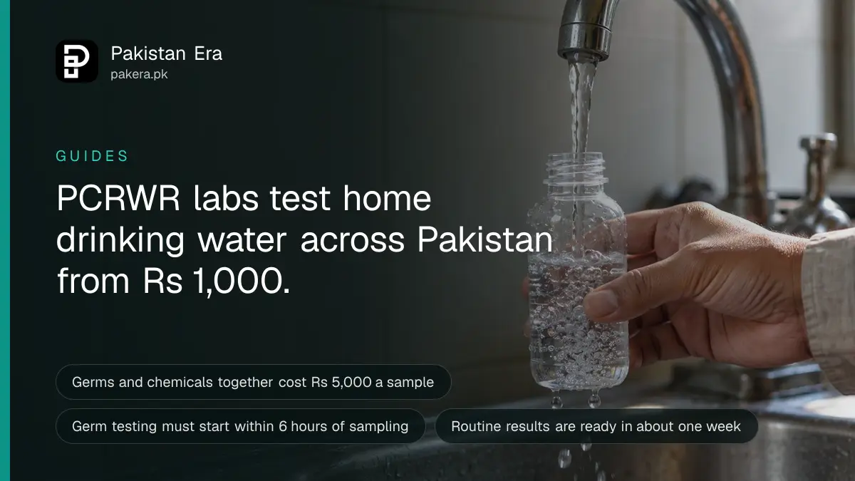 A hand filling a small clear sample bottle from a thin stream of tap water over a steel kitchen sink