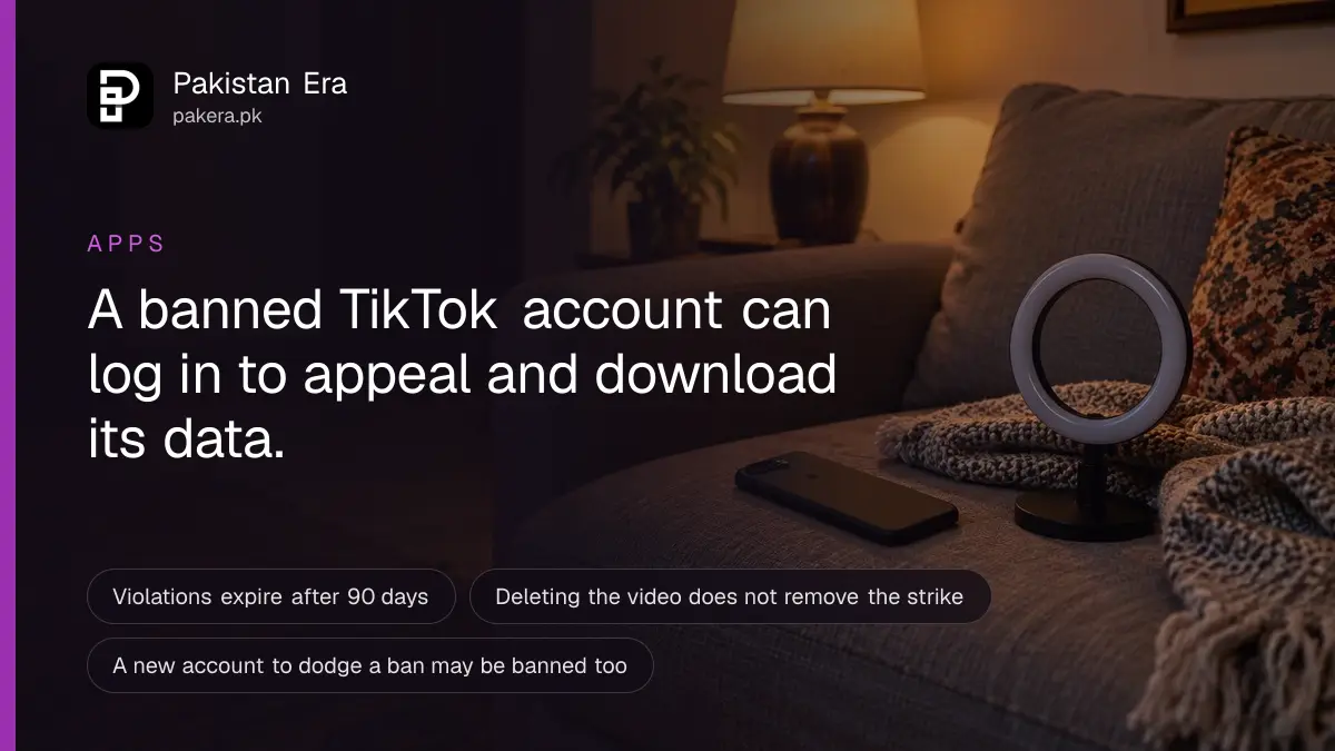 A dark phone resting on a sofa cushion beside a small ring light in a softly lit room