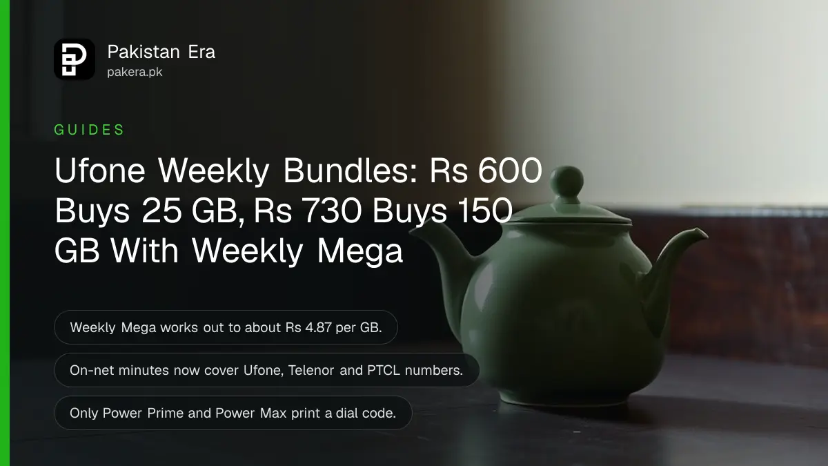 A green ceramic teapot on a dark wooden table against a plain cream wall in soft daylight