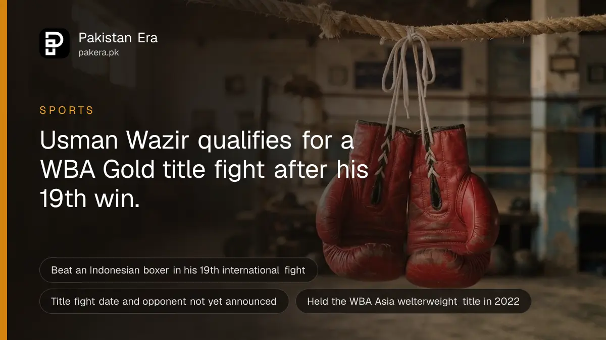 A pair of red leather boxing gloves hanging by their laces from a thick rope in an empty gym in warm light