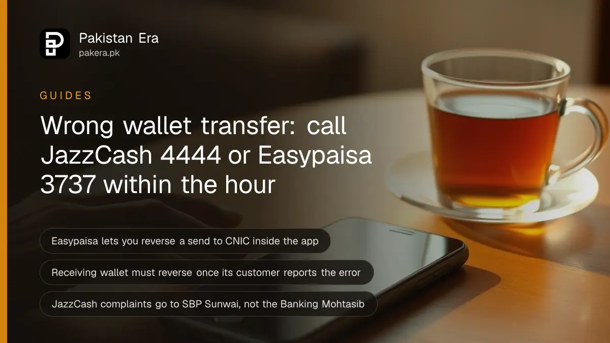 Two hands holding a smartphone face down over a small shop counter beside a cup of tea and a few coins